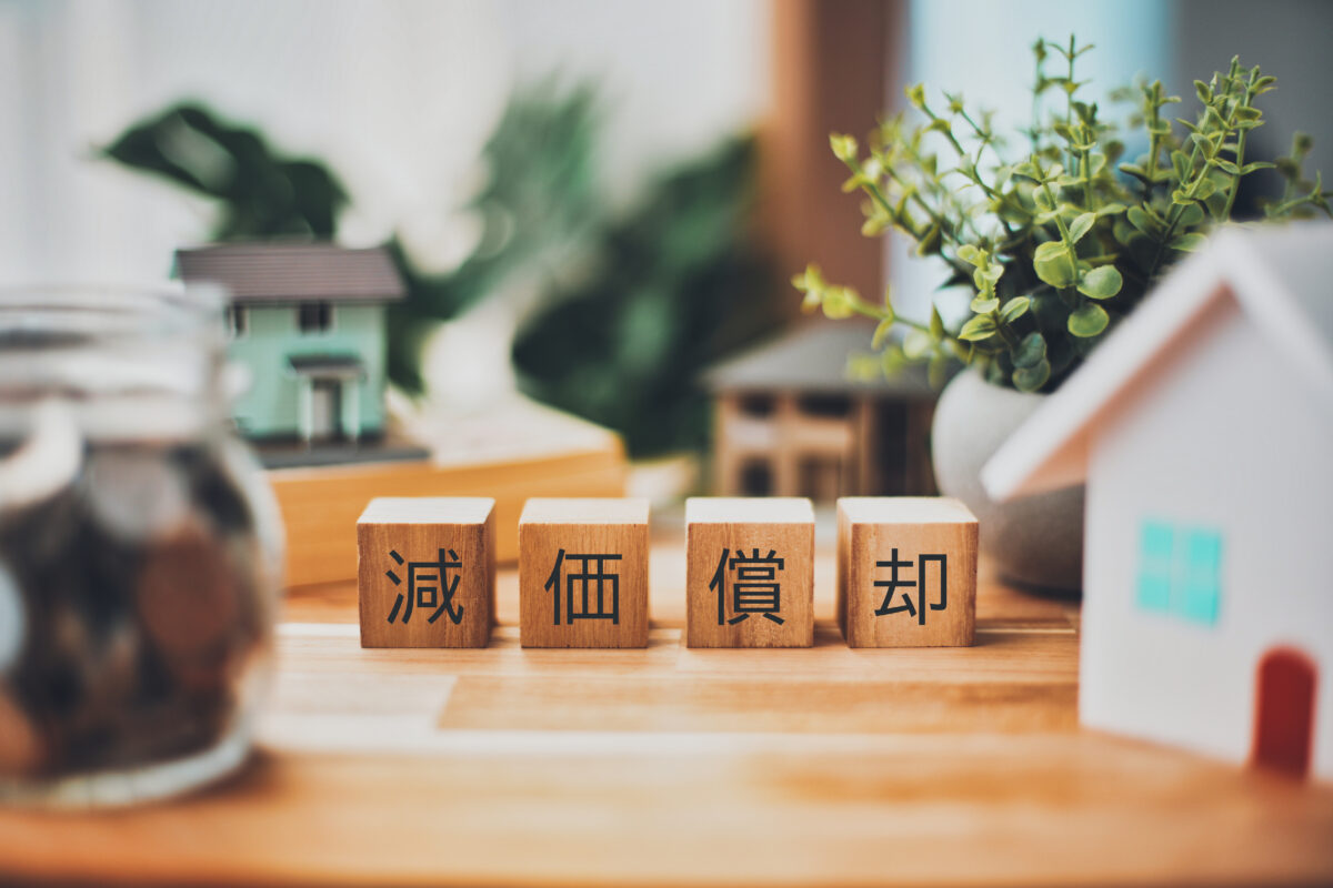 減価償却の文字と不動産ビジネスイメージ